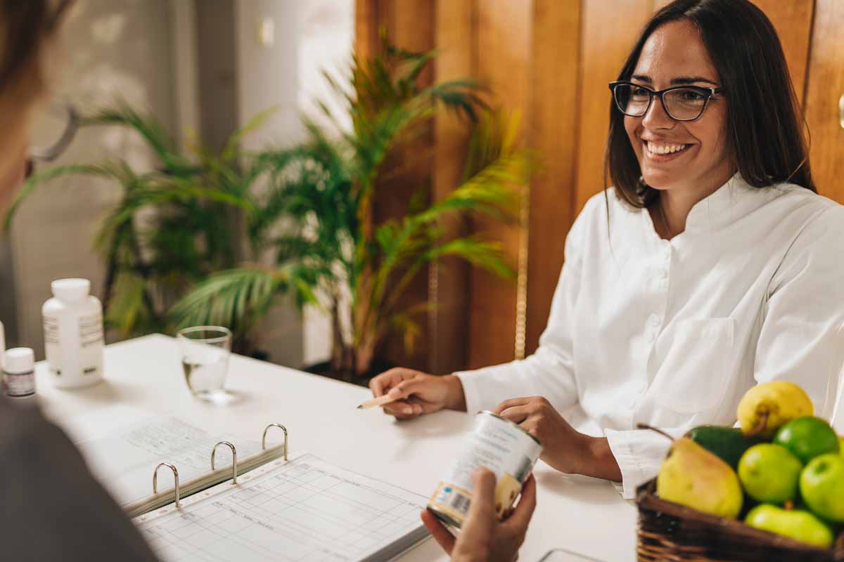 Nutricionista dando orientações de saúde em uma consulta com paciente 